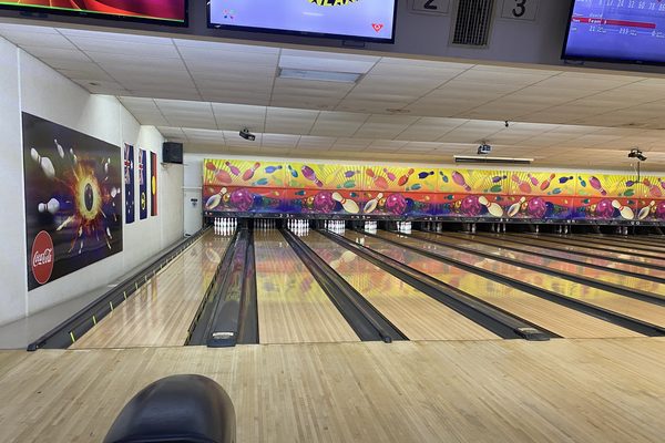 Row of polished tenpin lanes leading to the pins, typical of bowling alleys in Malaysia
