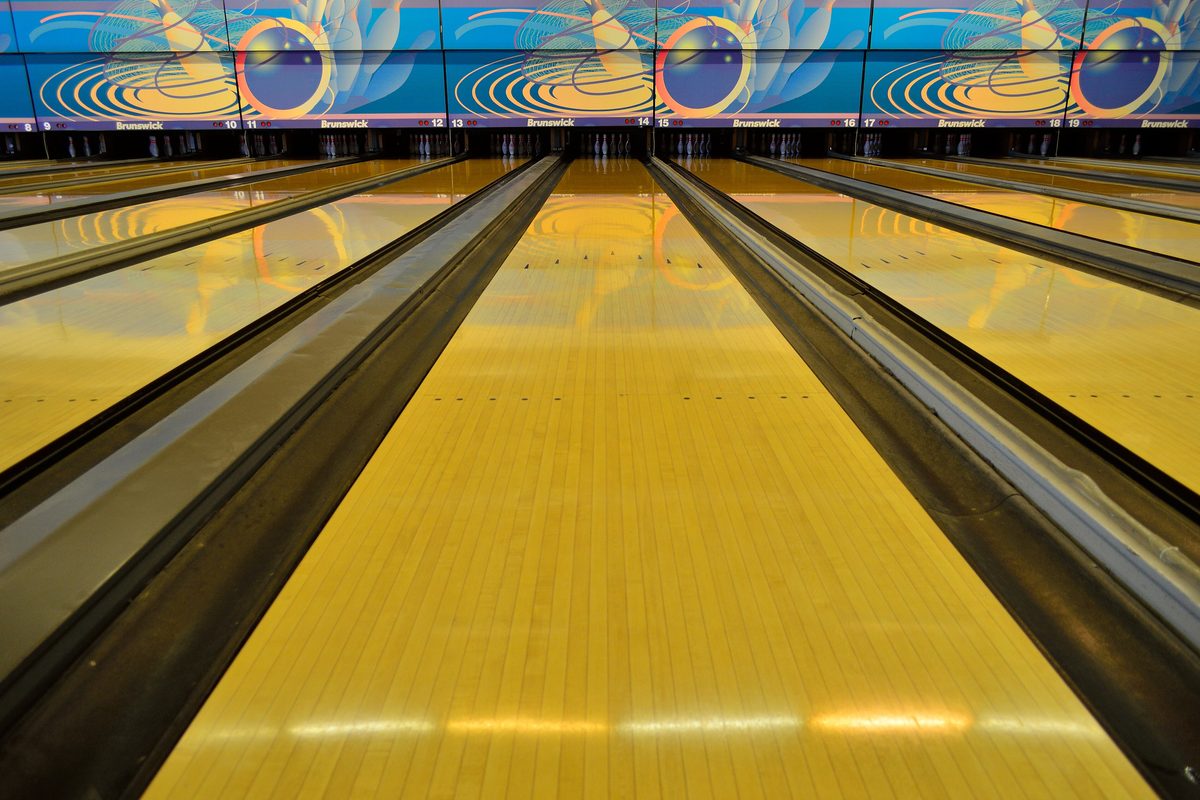 Polished wooden lane seen from the approach, the surface where bowling oil patterns are applied