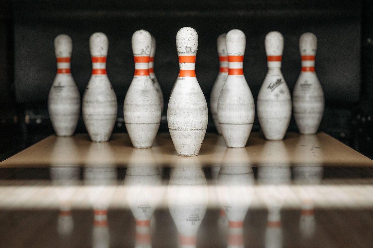 Close-up of ten white pins on the pin deck, the target in all bowling rules