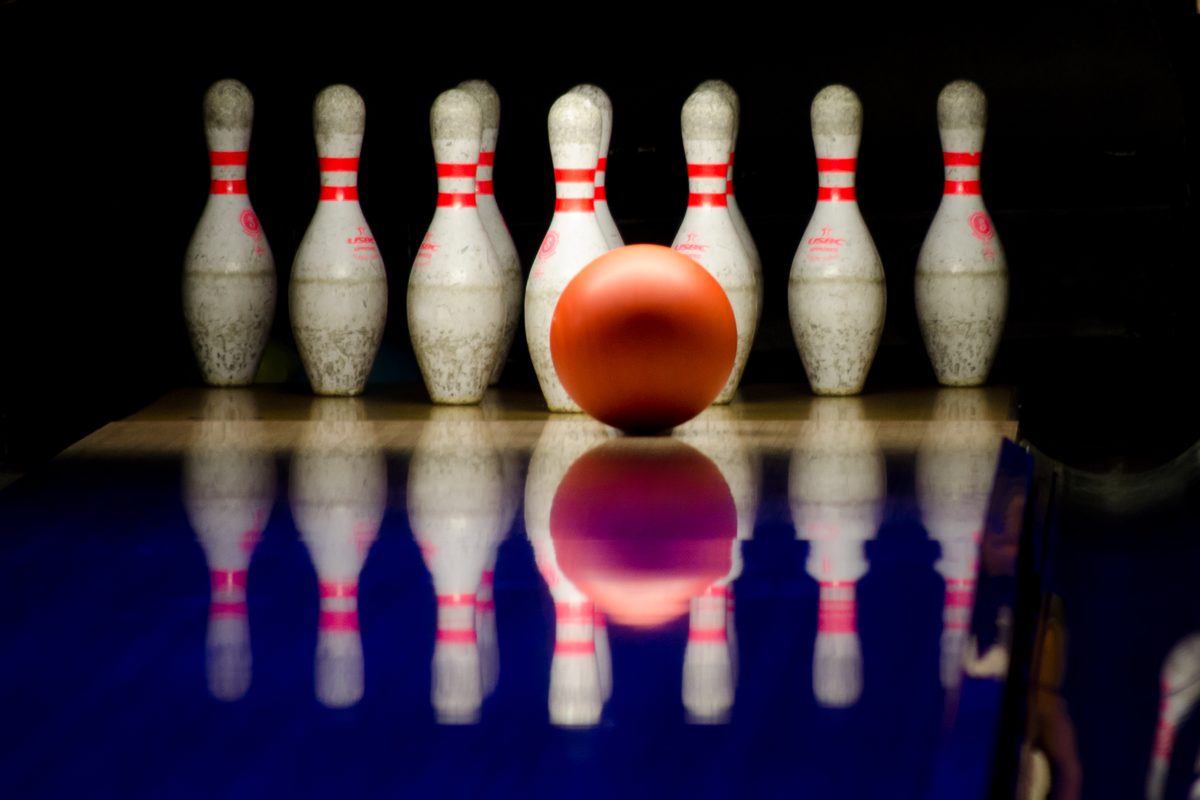Red ball about to hit a full rack of pins, the strong pocket hit Hammer bowling balls are built for